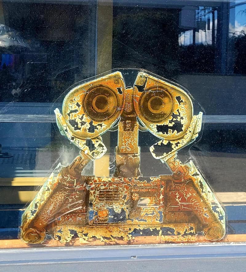 Rusty, weathered vintage telephone with peeling paint and exposed metal.