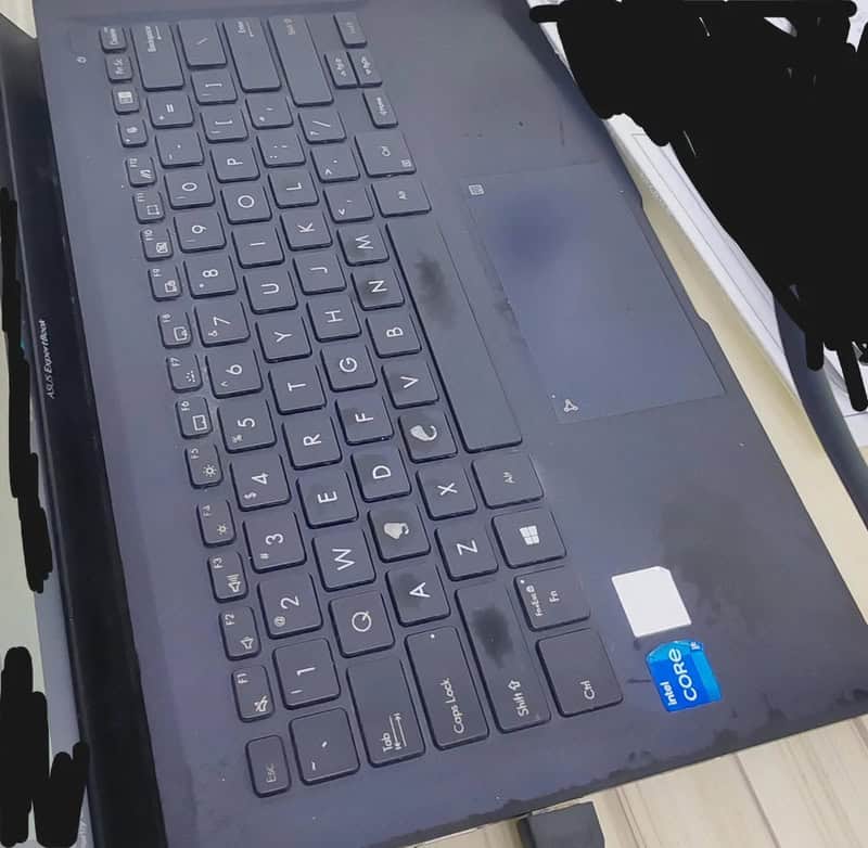 Close-up of a black laptop keyboard with a blue Intel Core i5 sticker.