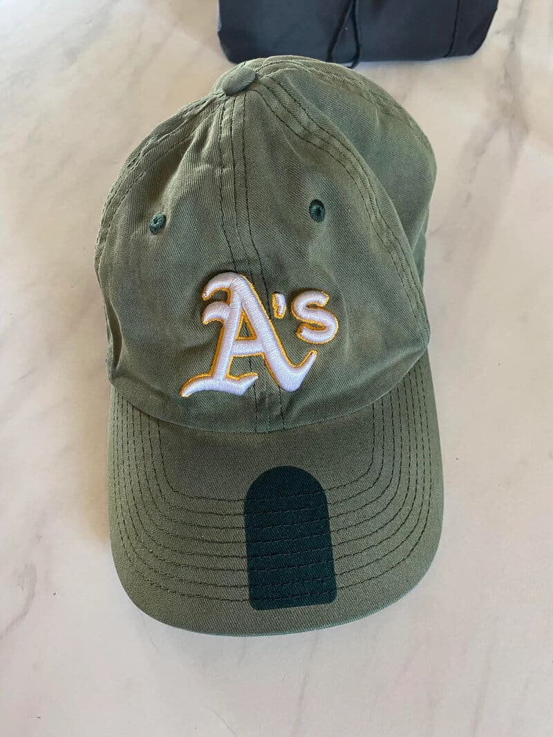Green Oakland Athletics baseball cap with white and gold A's logo on front.
