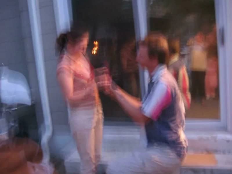 Blurred image of a woman and a man arguing through a glass door.