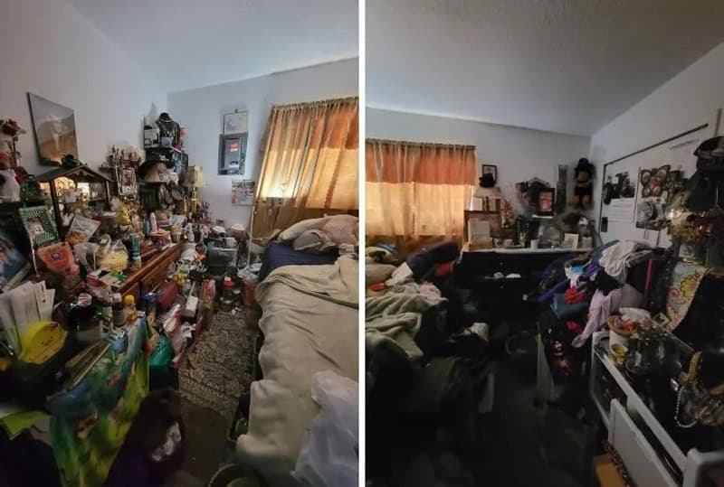Cluttered room with two beds, shelves, and various items, showing disorder.