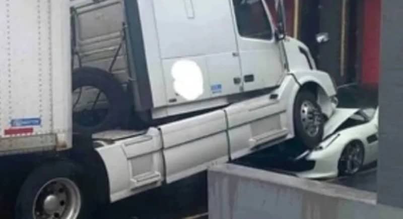 Semi-truck appears to be floating above a small car, creating an optical illusion.