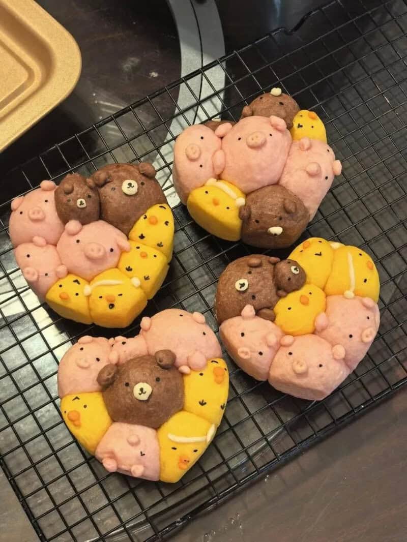 Decorative cookies shaped like bears and chicks on a cooling rack.