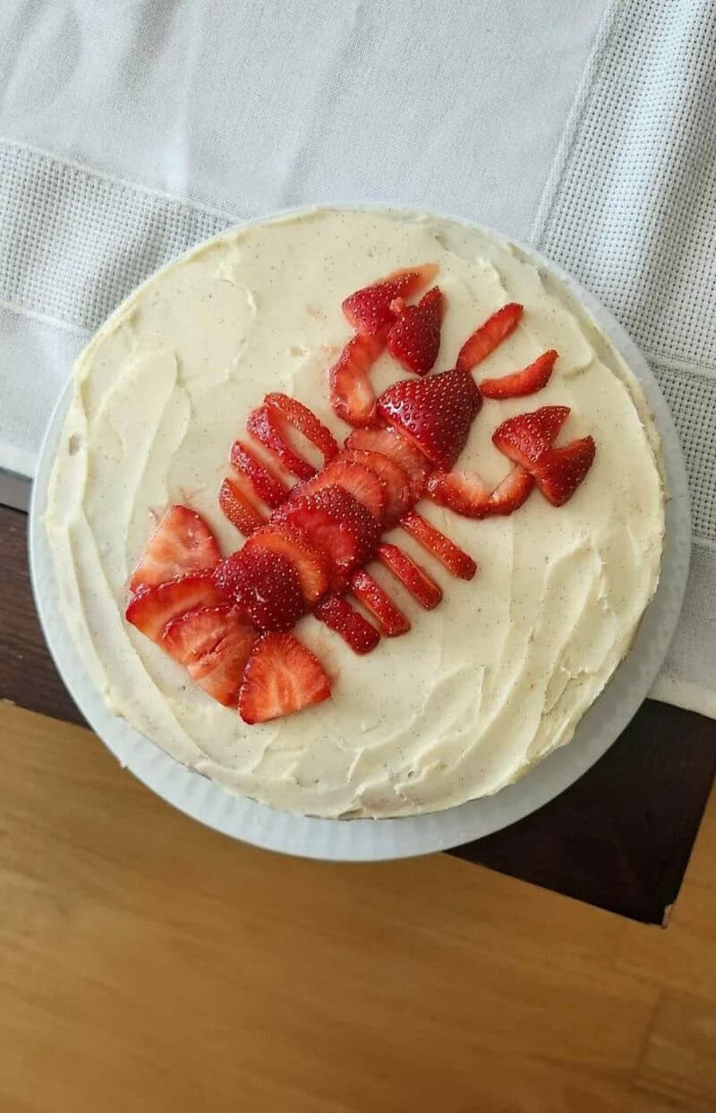 Lobster-shaped cake decorated with strawberries on top.