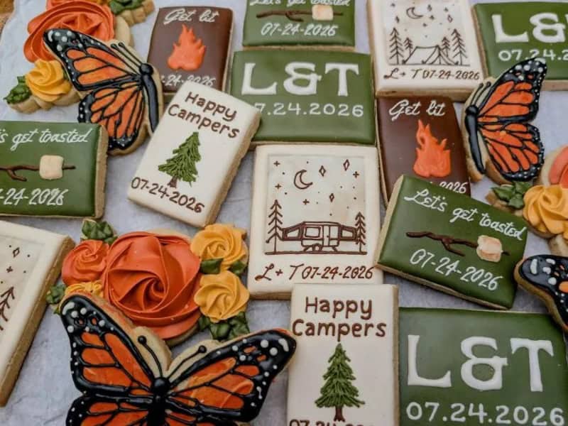Decorated cookies with camping and nature themes, butterflies, and personalized messages.