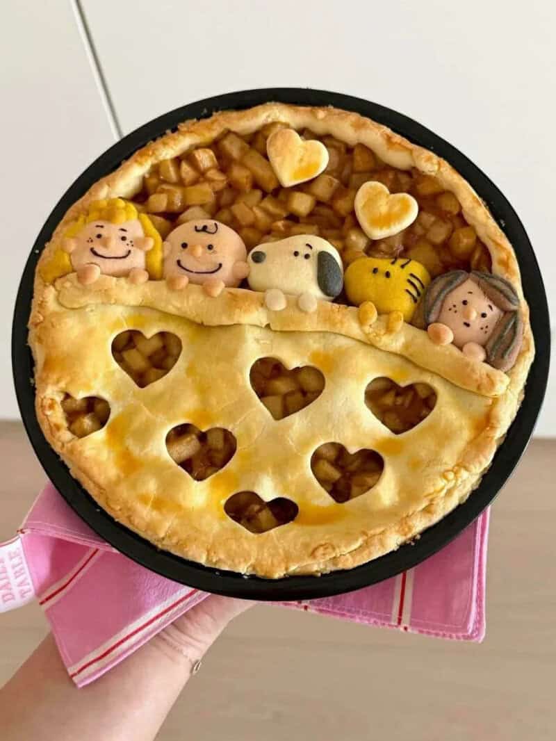 Decorative pie with character-shaped toppings and heart-shaped cutouts.