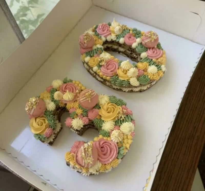 Number 8 and 9 decorated cookies with colorful frosting and sprinkles in a box.