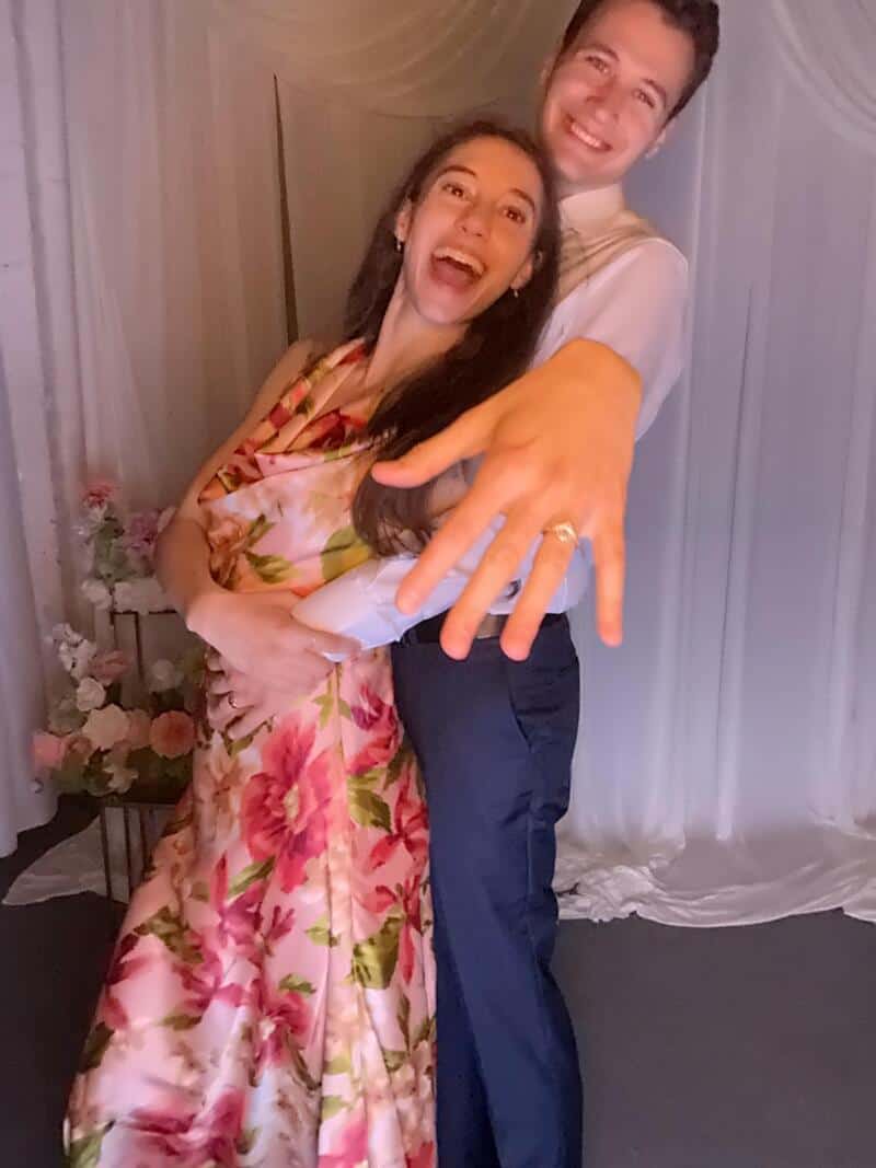 Happy couple showing off wedding rings at a celebration.