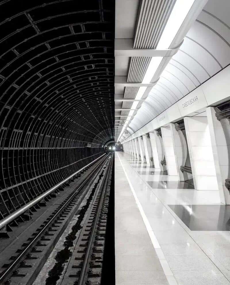 Contrasting tunnel and station platform with a vanishing point perspective.
