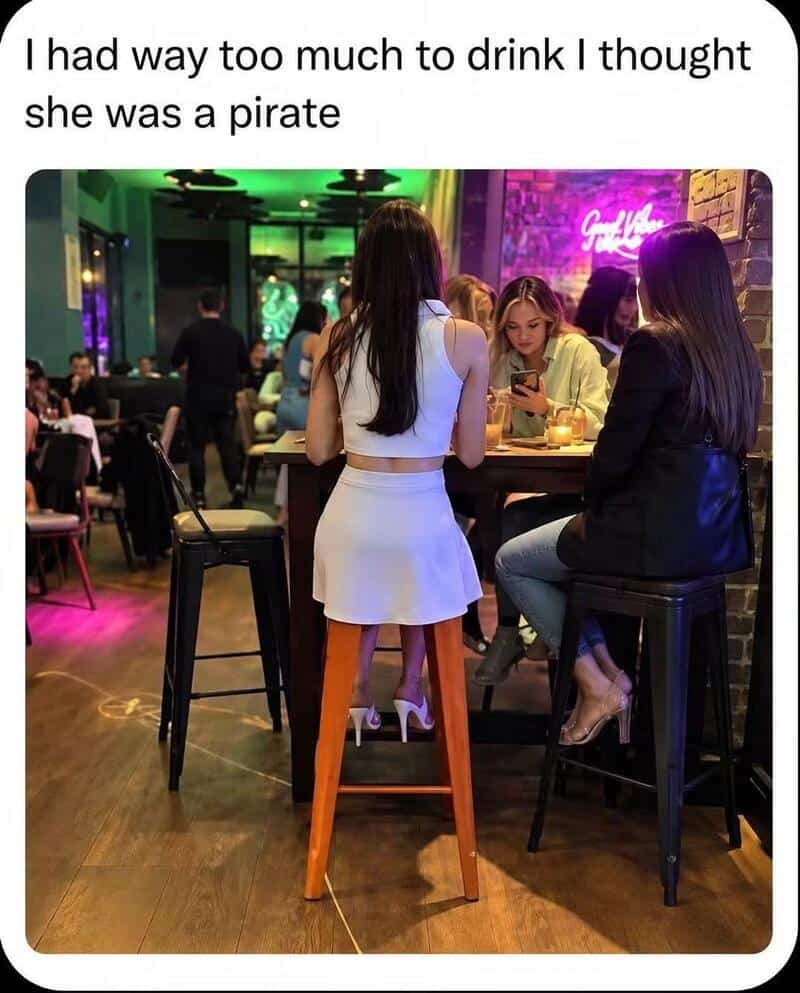 Group of women at a bar, one with a tall stool, creating a confusing perspective.