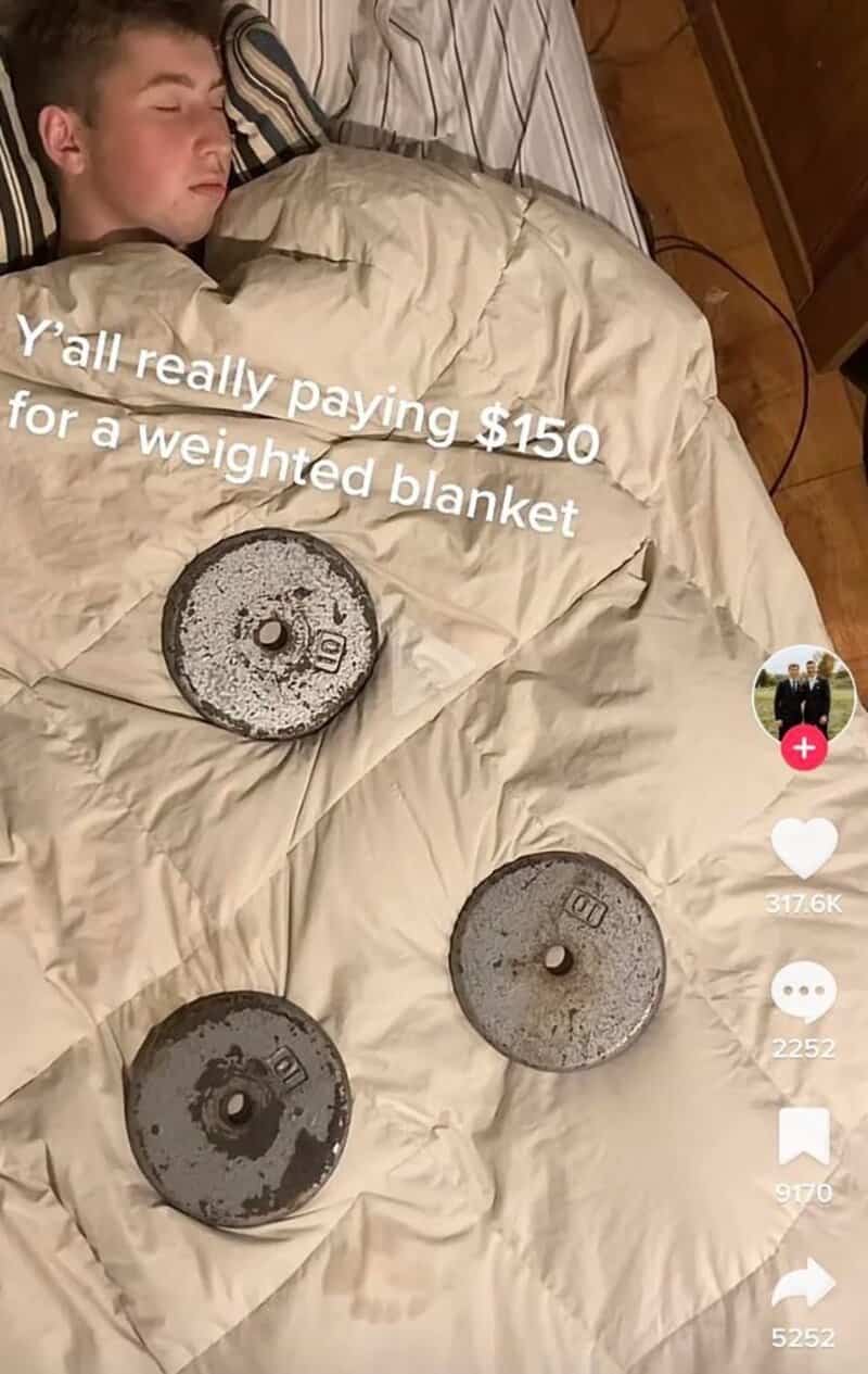 Sleeping person with three weights on bed, caption about paying $150 for a weighted blanket.