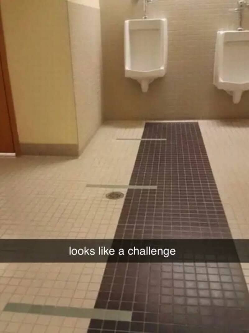 Restroom floor with a challenge pattern of tiles and lines.