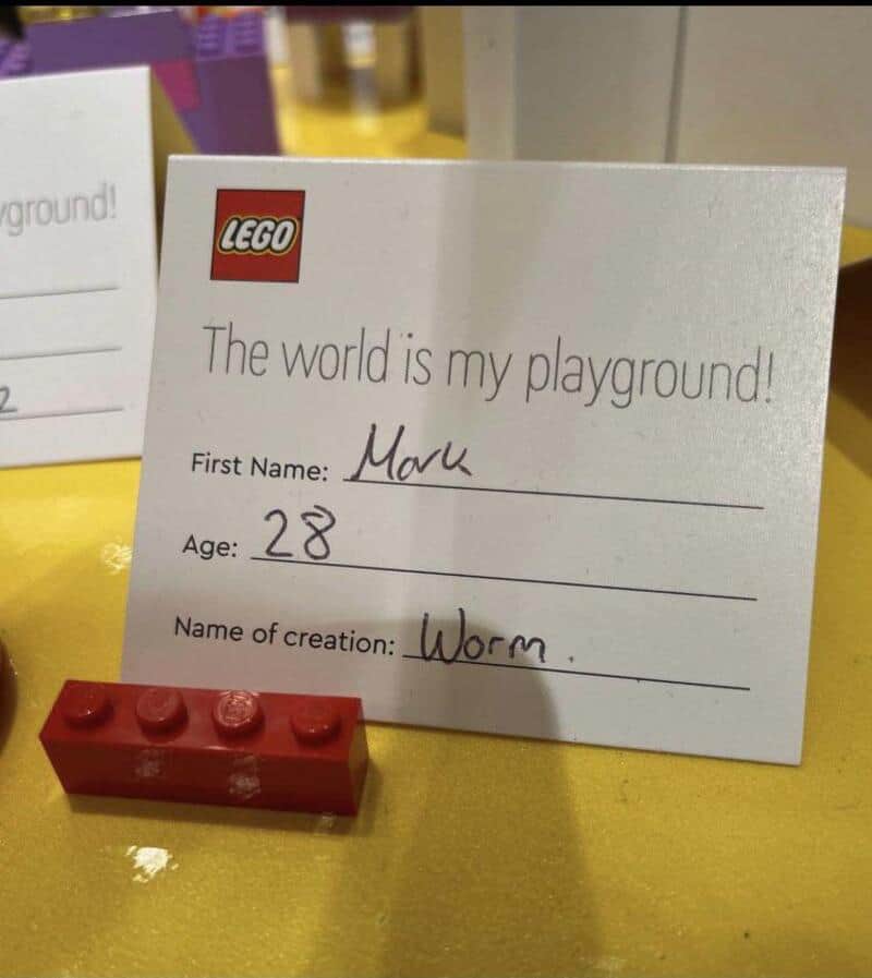 Lego sign with name Mark, age 28, and creation Worm, with a red Lego brick in front.