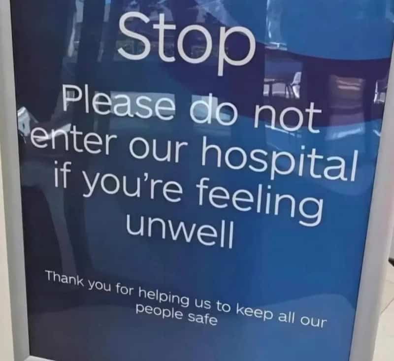 Stop sign with a message asking not to enter hospital if feeling unwell.