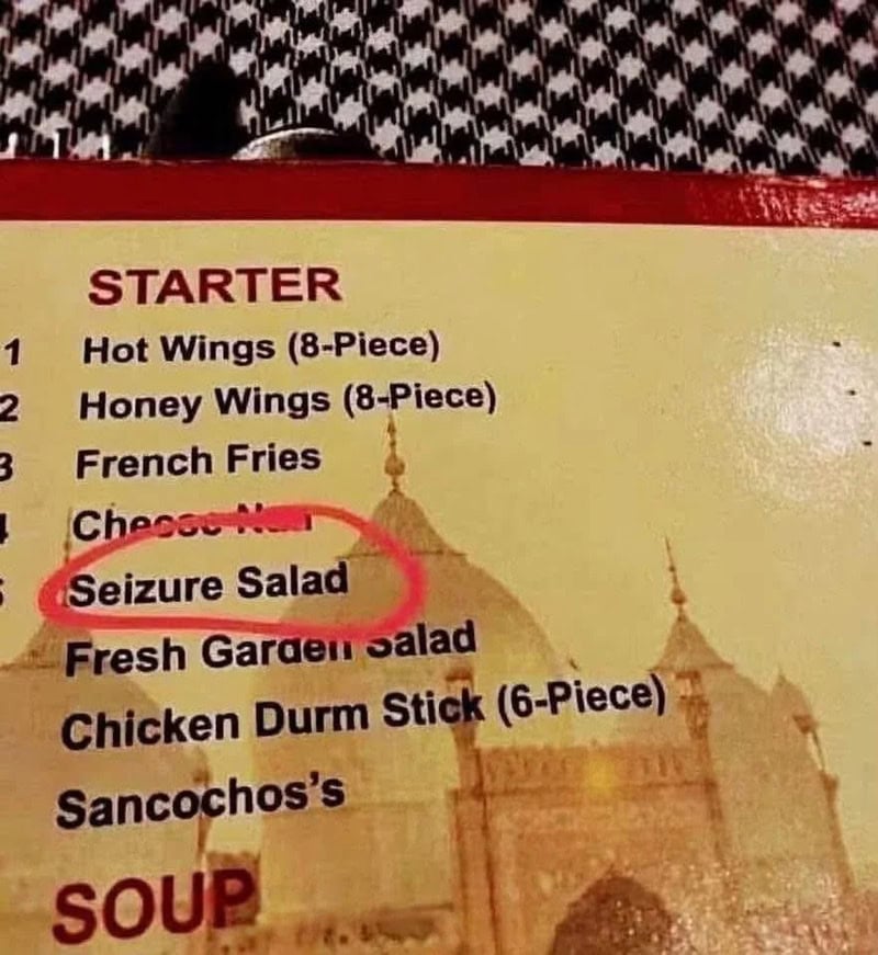 Menu with 'Seizure Salad' listed under starters, with a background of a temple.
