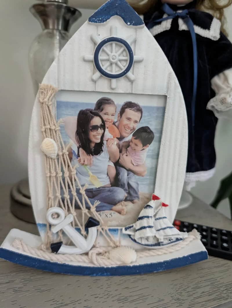 Photo of a family in a boat-shaped picture frame with nautical decorations.