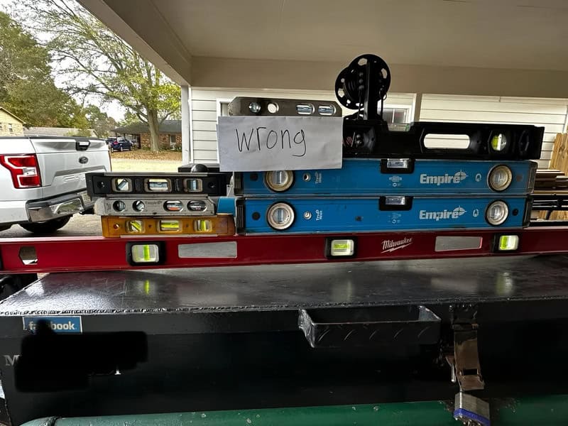 Stacked levels with a sign that says 'wrong' on top of a construction level.