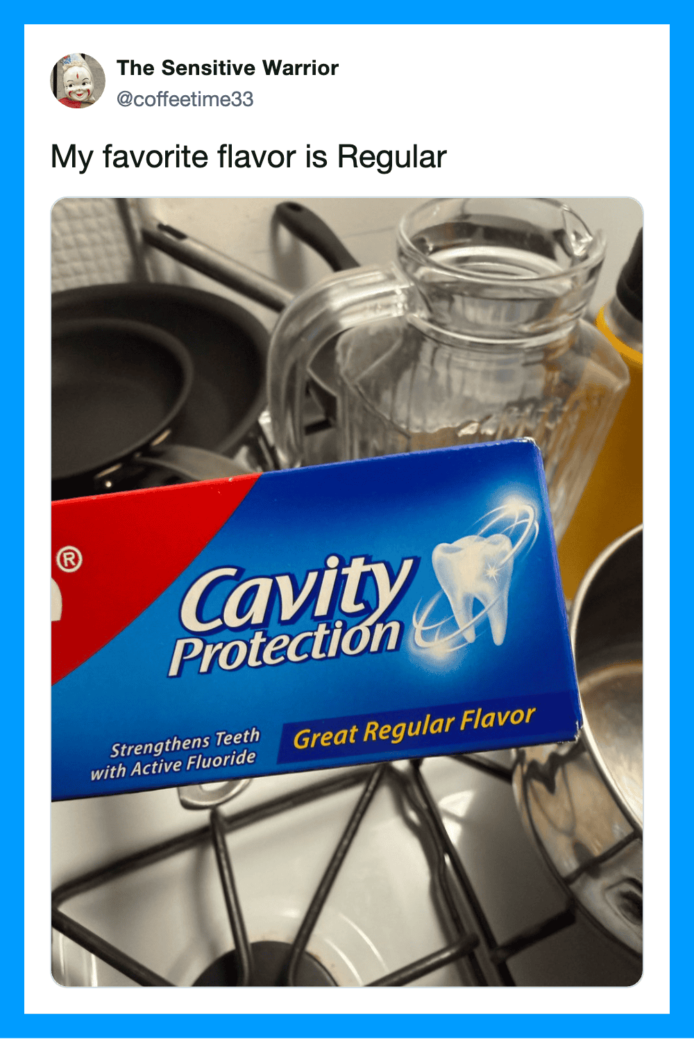 A box of Cavity Protection toothpaste with a glass pitcher and kitchen utensils in the background.