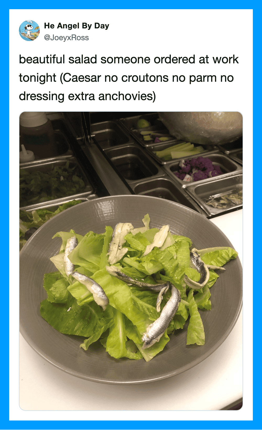 Salad with lettuce and anchovies in a bowl at work, with a salad bar in the background.
