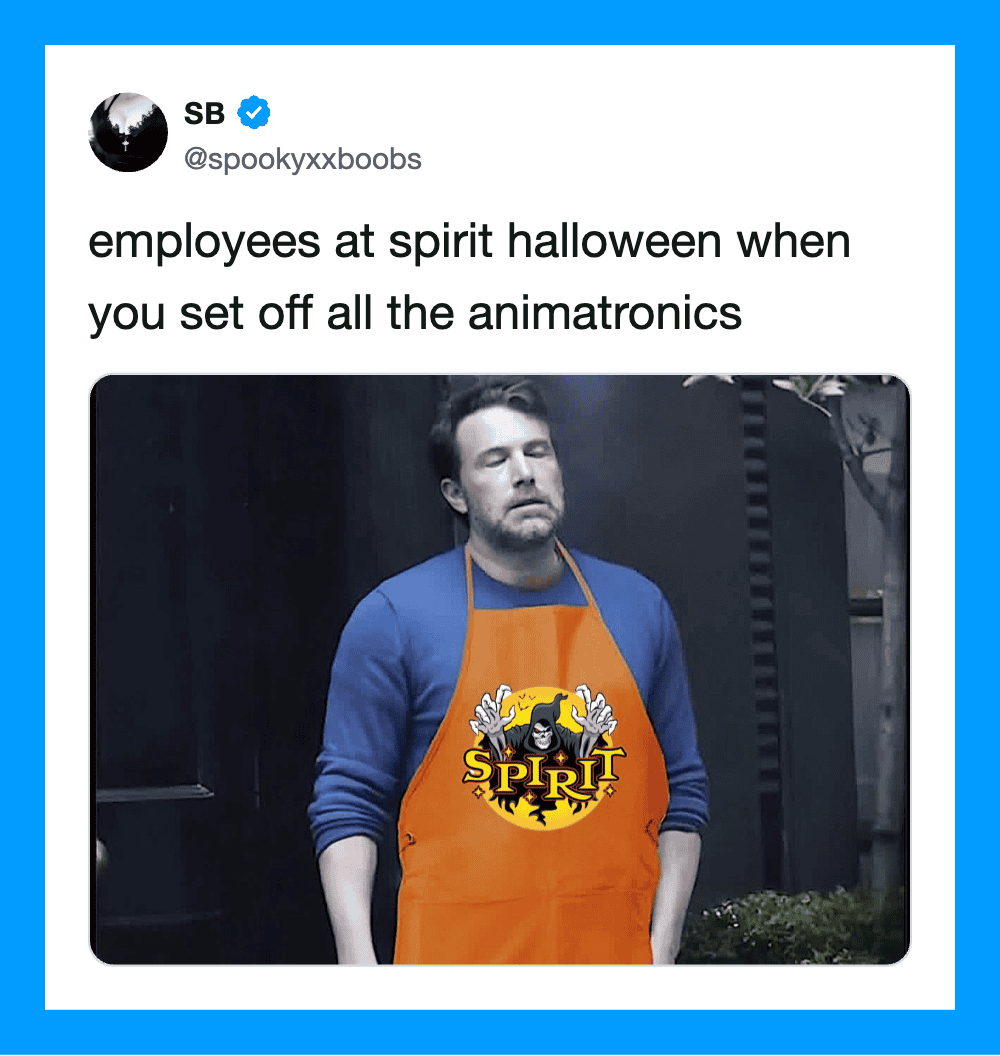 Employee at Spirit Halloween wearing an orange apron with a black and yellow logo.