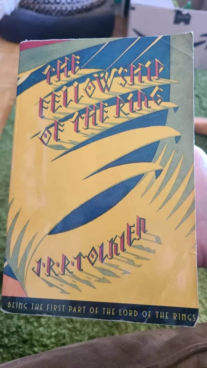The Fellowship of the Ring by J.R.R. Tolkien book cover with yellow and blue design.
