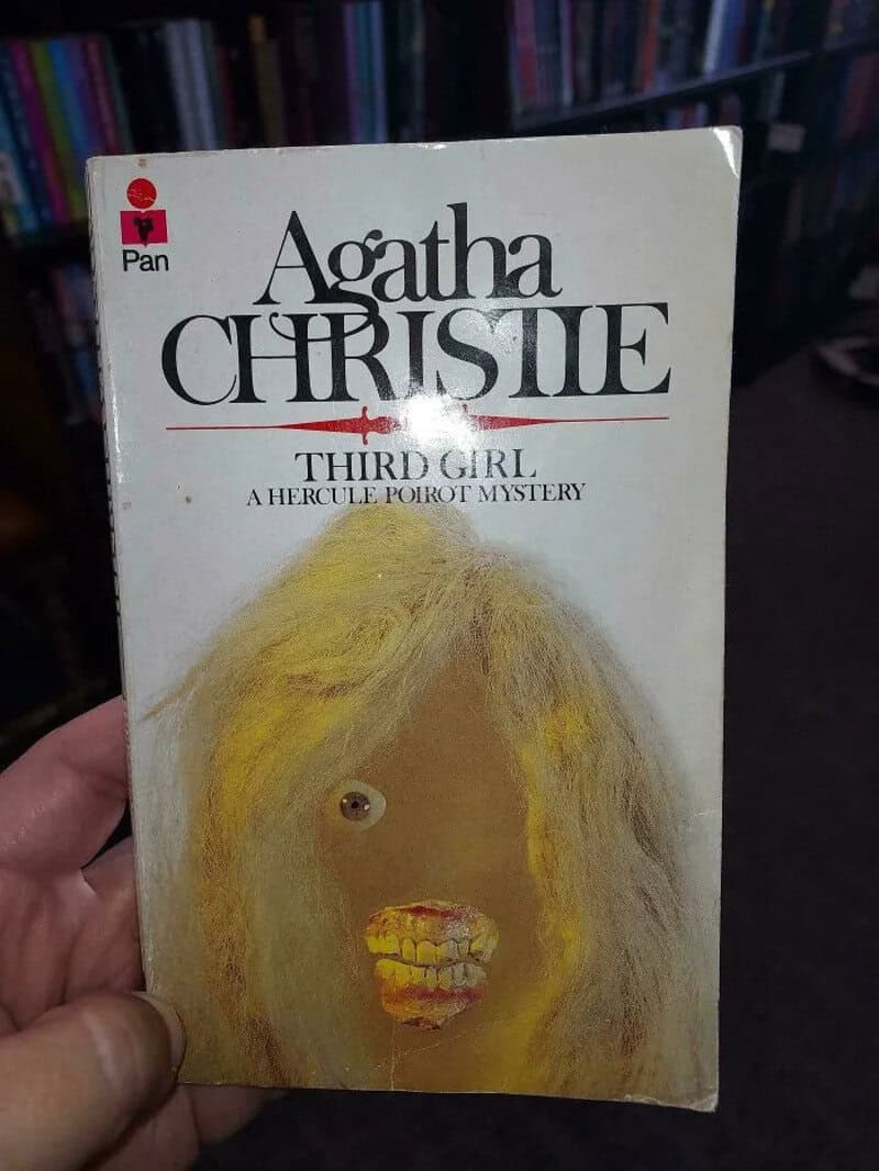 Third Girl by Agatha Christie, a book cover with a face illustration and a red cross.