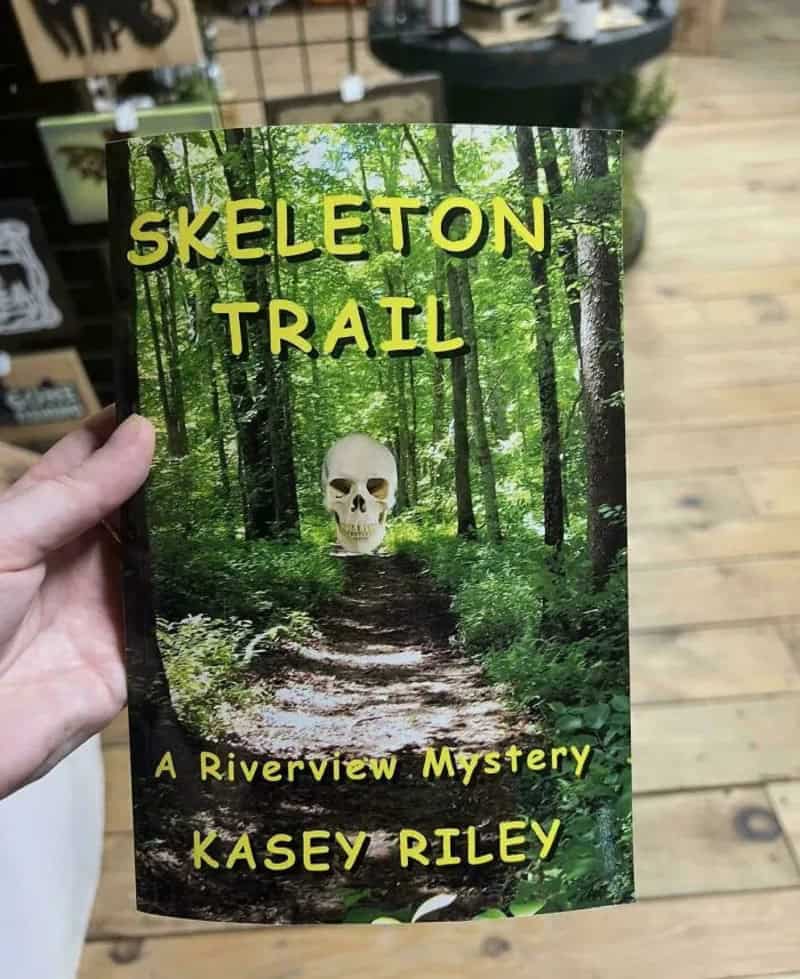 Book cover titled 'Skeleton Trail' with a forest background and a skull image.