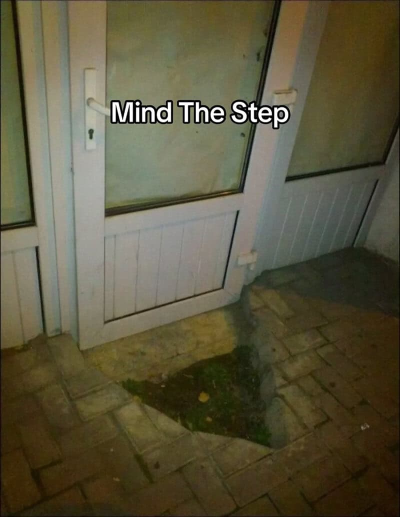 Door with a large hole in the floor beneath it, with the text 'Mind The Step' overlaid.