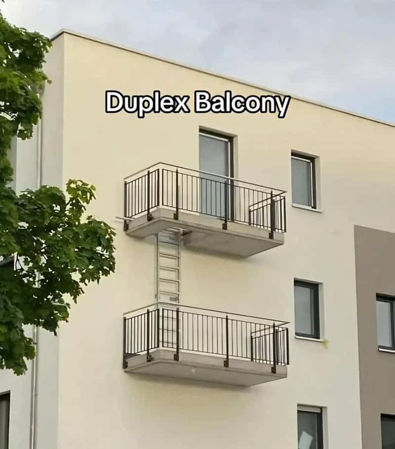 Duplex balcony with two levels and metal railings on a white building.