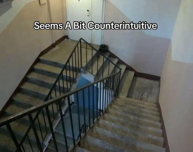 Staircase with a railing and a sign saying 'Seems A Bit Counterintuitive'.