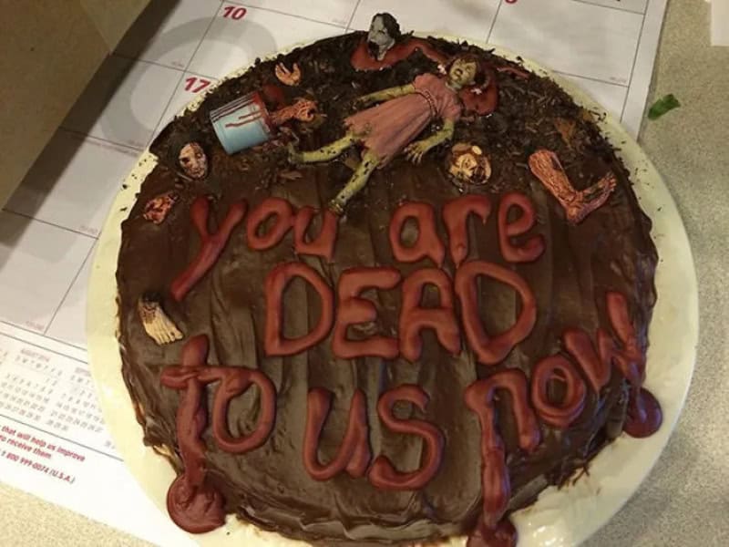 Cake with zombie figures and the message 'you are DEAD to US now'.
