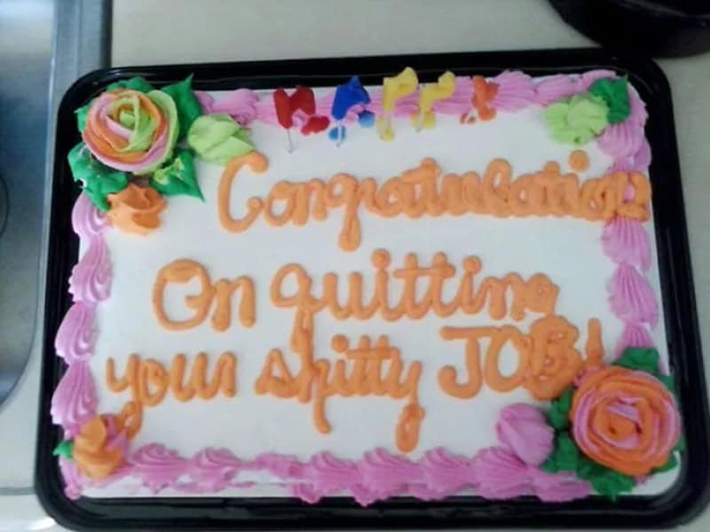 Celebration cake with colorful flowers and 'Congratulations on quitting your sh*tty job!' message.