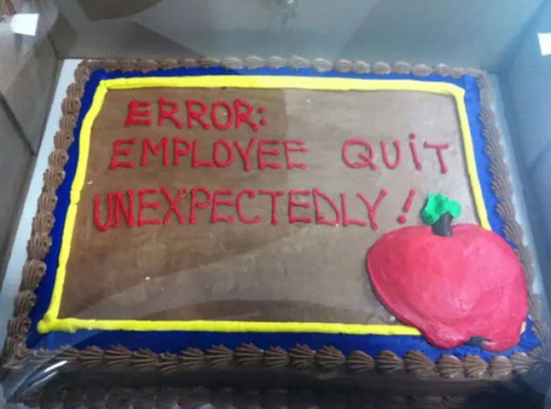 Cake with error message: Employee quit unexpectedly! and a red apple decoration.