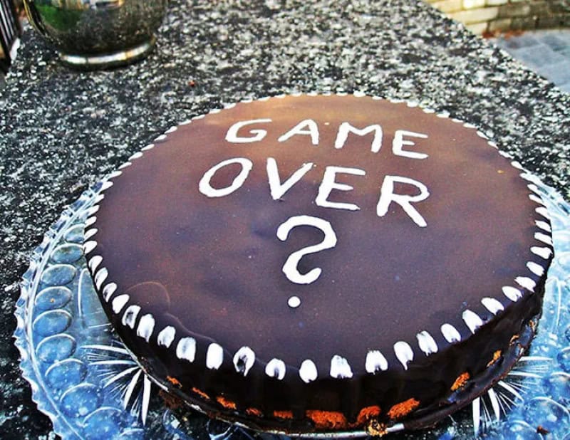 Chocolate cake with 'GAME OVER ?' written on top in white icing.