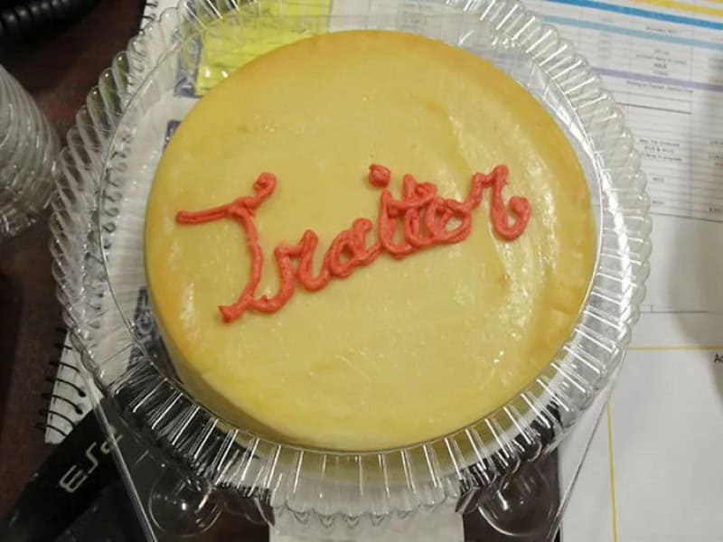 Cheesecake with 'Tractor' written in red icing on top.