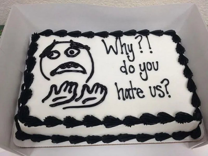 Cake with a sad face drawing and the text 'Why?! do you hate us?'.
