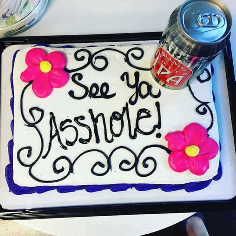 Cake with pink flowers and the message 'See You Asshole!'.