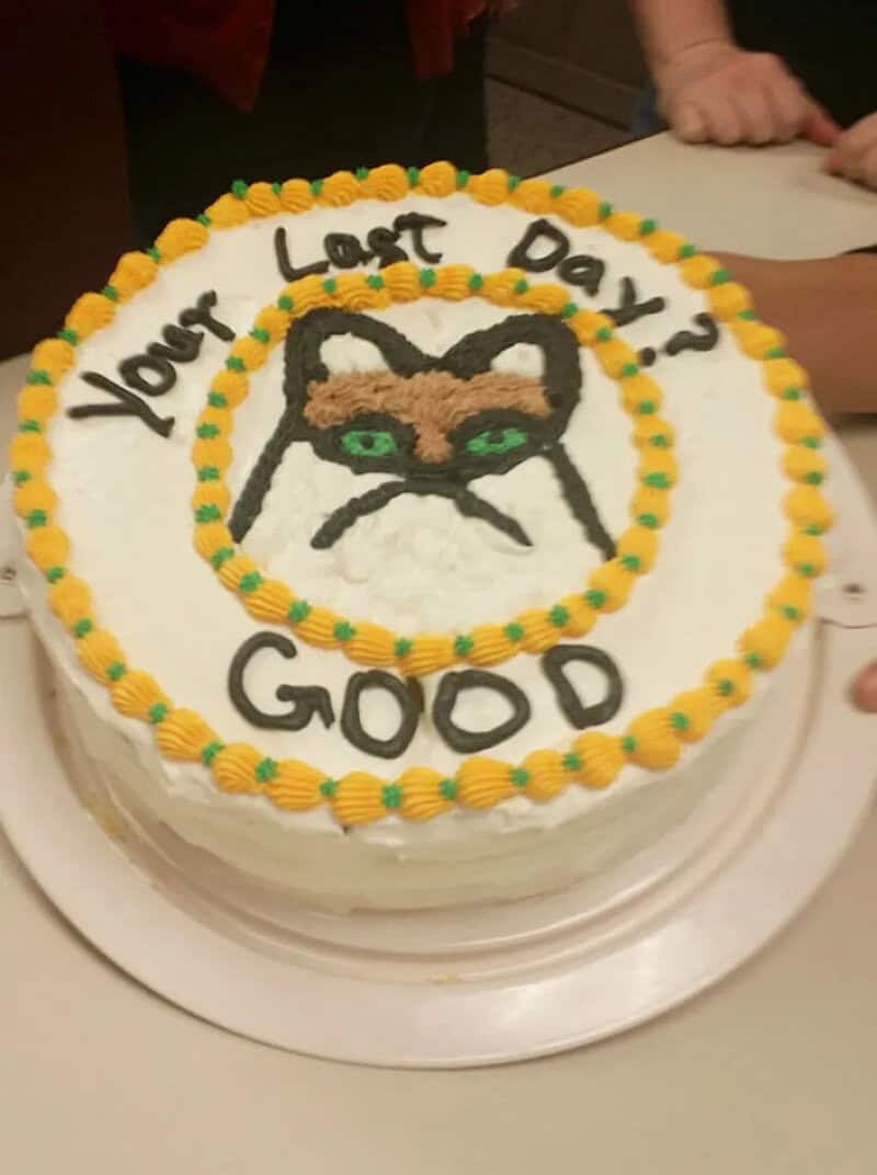 Cake with a cat face and the words 'Your Last Day? Good' on it.