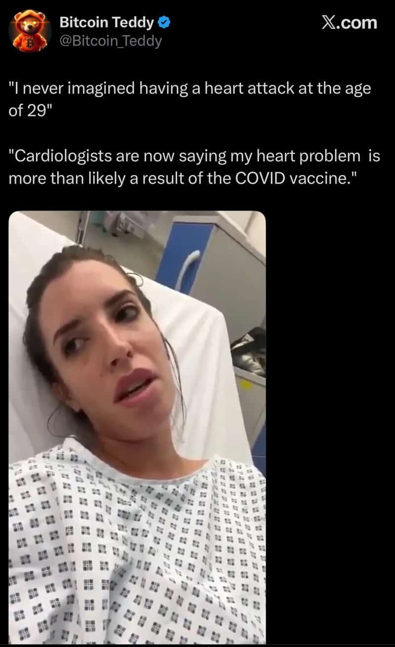 Woman in hospital gown lying in bed, talking to the camera.