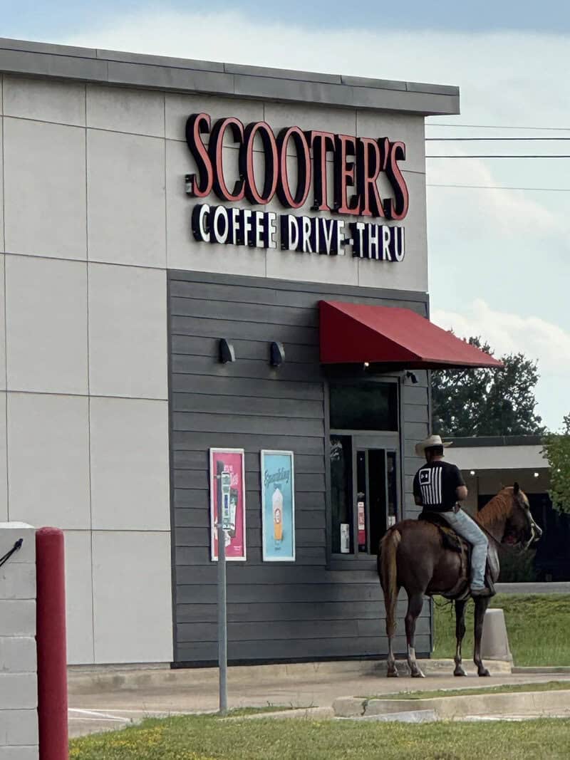 Scooter's Coffee drive-thru with a person on horseback outside.