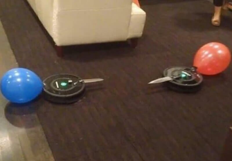 Two balloons, one blue and one red, are near two laser tag guns on the floor.