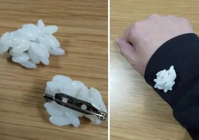White plastic flower hair clip and a hand wearing a similar clip on the wrist.