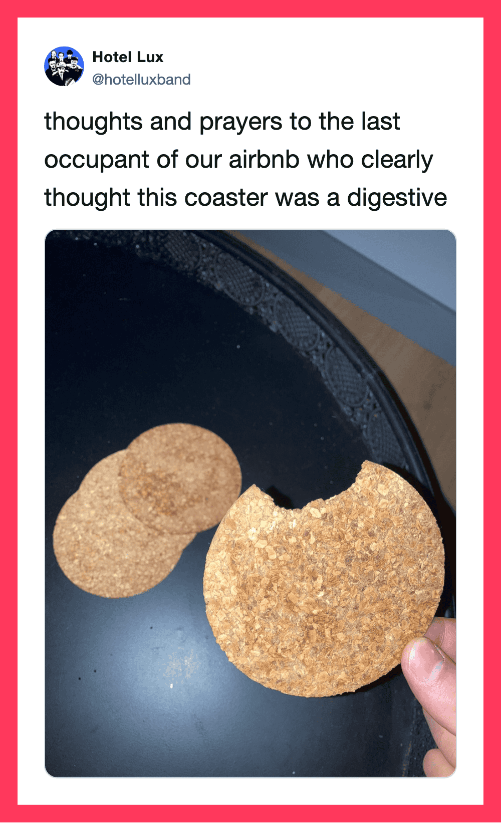 Photo of two round, golden-brown cookies on a black plate, with a hand holding one cookie.