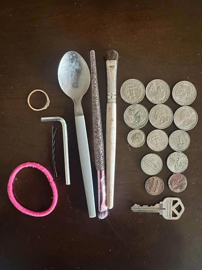 Various household items and coins on a dark surface.