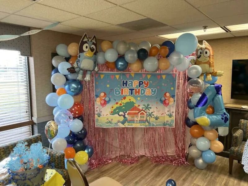 Colorful birthday party decoration with balloons and a 'Happy Birthday' banner.