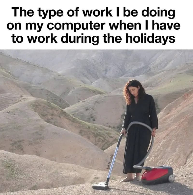 Woman working on her computer while vacuuming outdoors in a hilly landscape.