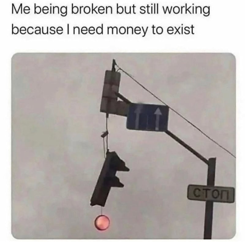 Broken traffic light with a gun hanging from it, and a stop sign in the background.