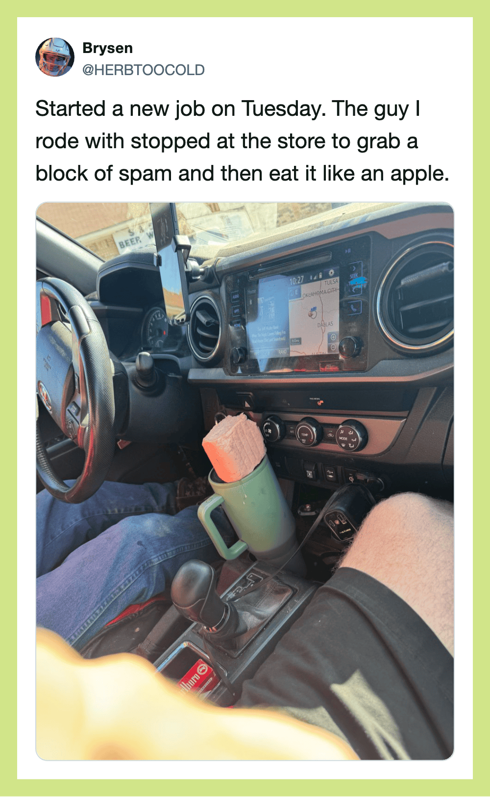Photo of a truck interior with a phone mounted on the dashboard and a coffee mug in the cup holder.