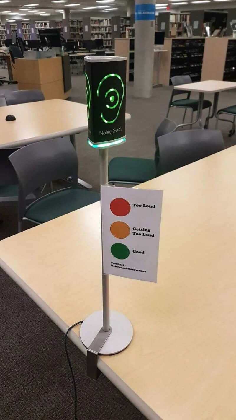 Device with green smiley face indicating 'Good' in a library setting.