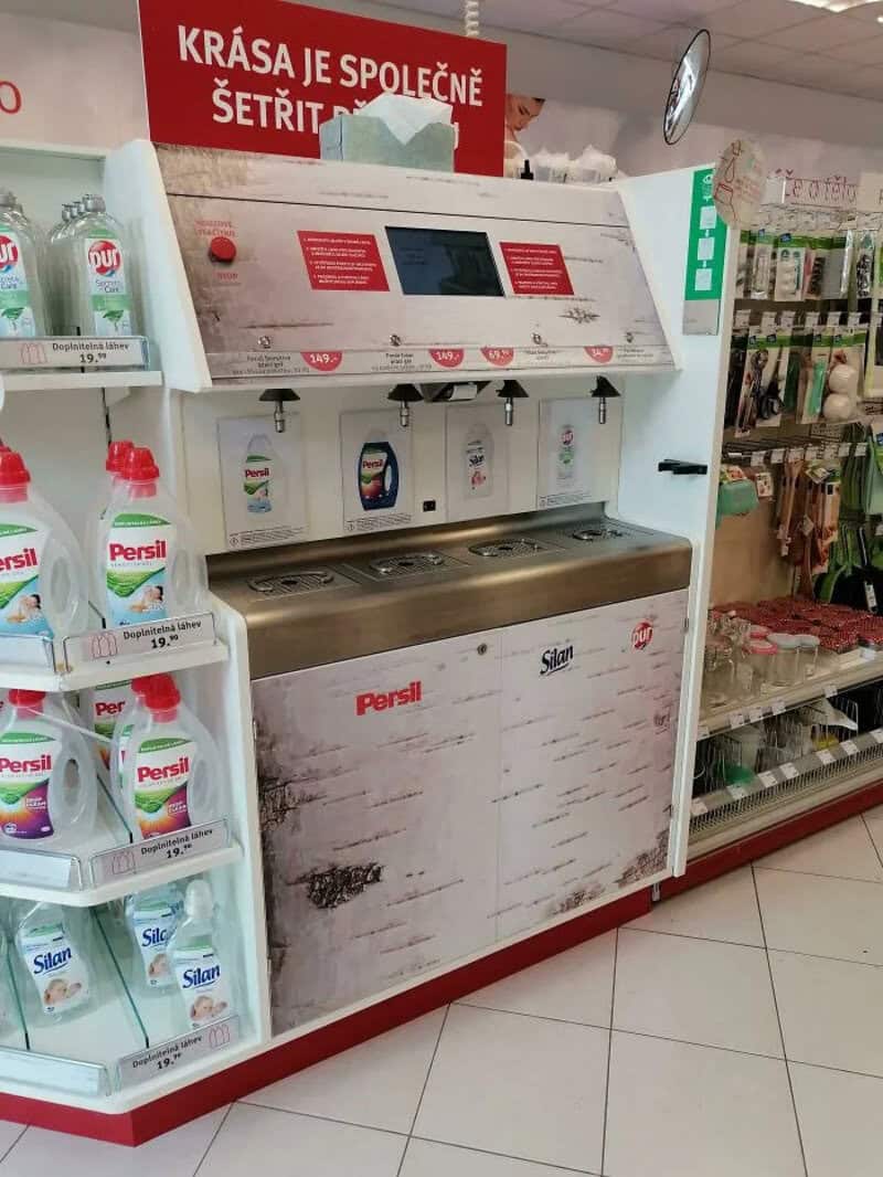 Self-service laundry station with Persil detergent bottles nearby.
